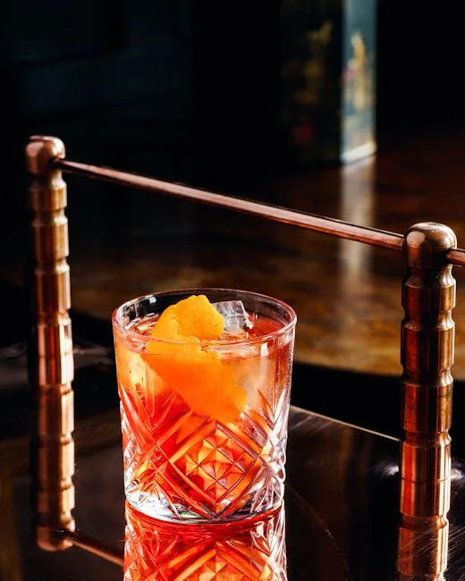 Cocktail orange dans verre taillé sur comptoir de bar à Milan