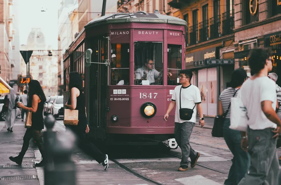 Tram rose historique 1847 marqué Milano, passants traversant rue milanaise