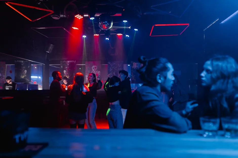 Club nocturne à Milan avec danseurs sous éclairages rouges et bleus.