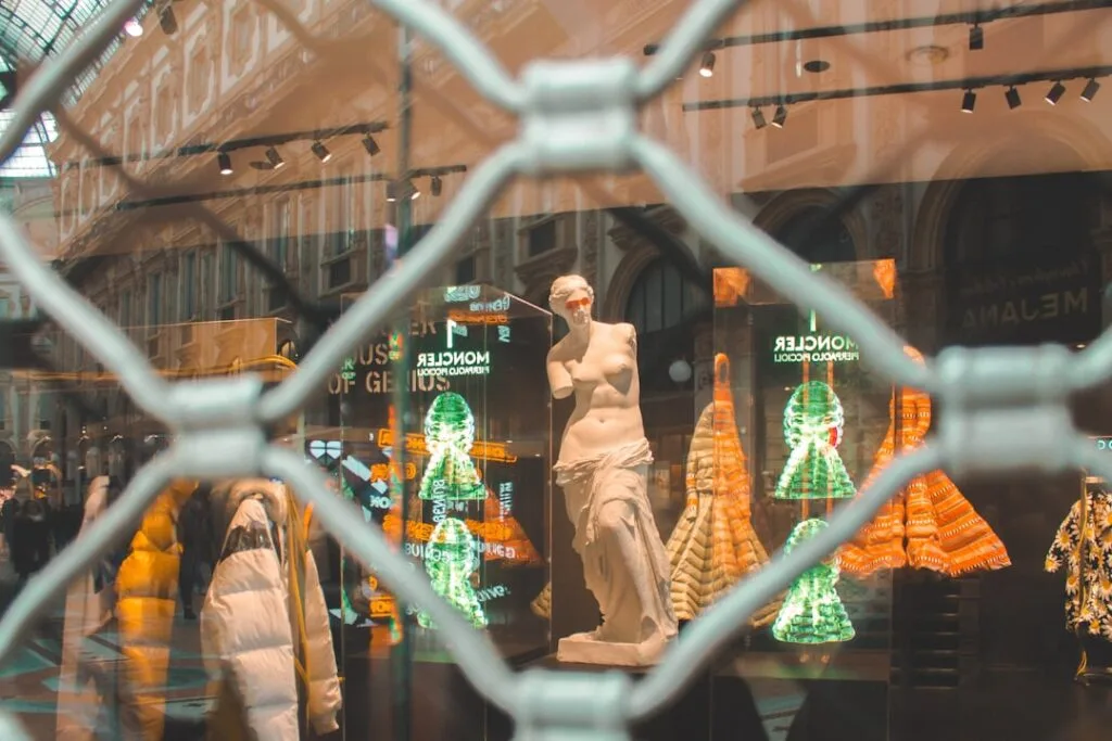 Vitrine fermée dans la Galleria à Milan montrant statue et vêtements