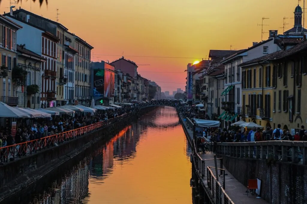 Coucher de soleil sur le canal Navigli, terrasses bondées à Milan
