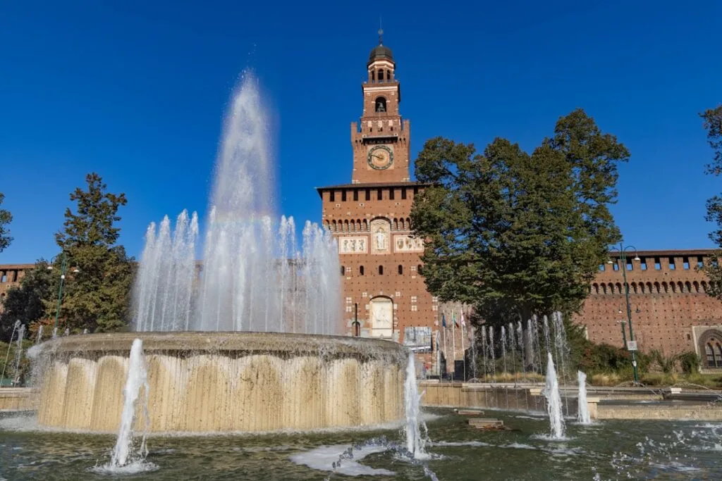 Fontaine devant le château Sforzesco à Milan sous ciel bleu