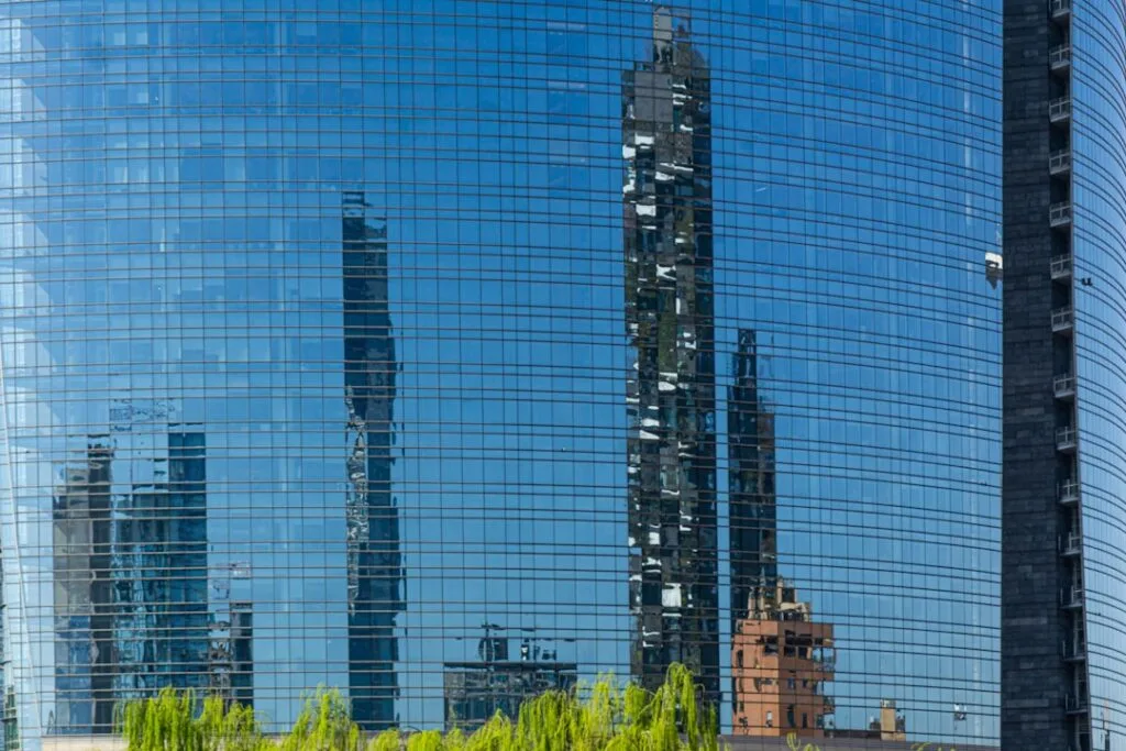 Reflets de gratte-ciel milanais sur façade vitrée bleue