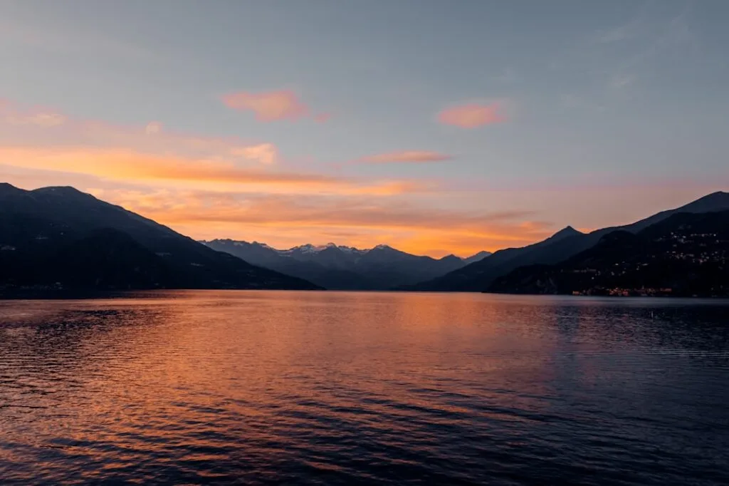Coucher de soleil orangé sur le lac de Côme, montagnes en silhouette