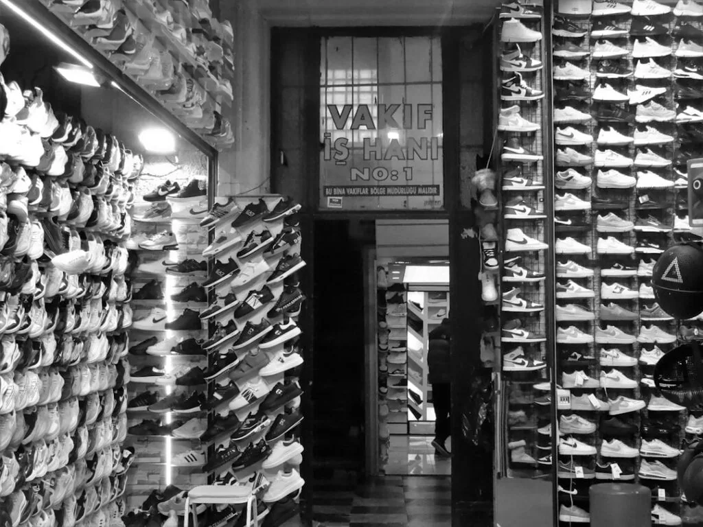 Boutique de sneakers aux murs couverts de paires, ambiance en noir et blanc