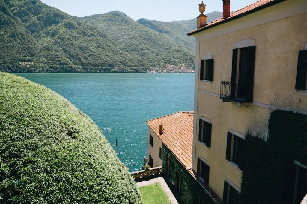 Façade de villa jaune et haie taillée dominant le lac de Côme