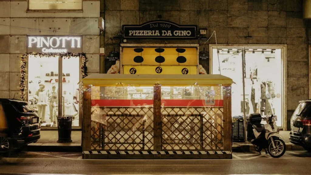 Abri chauffé devant Pizzeria Da Gino sur une rue milanaise animée