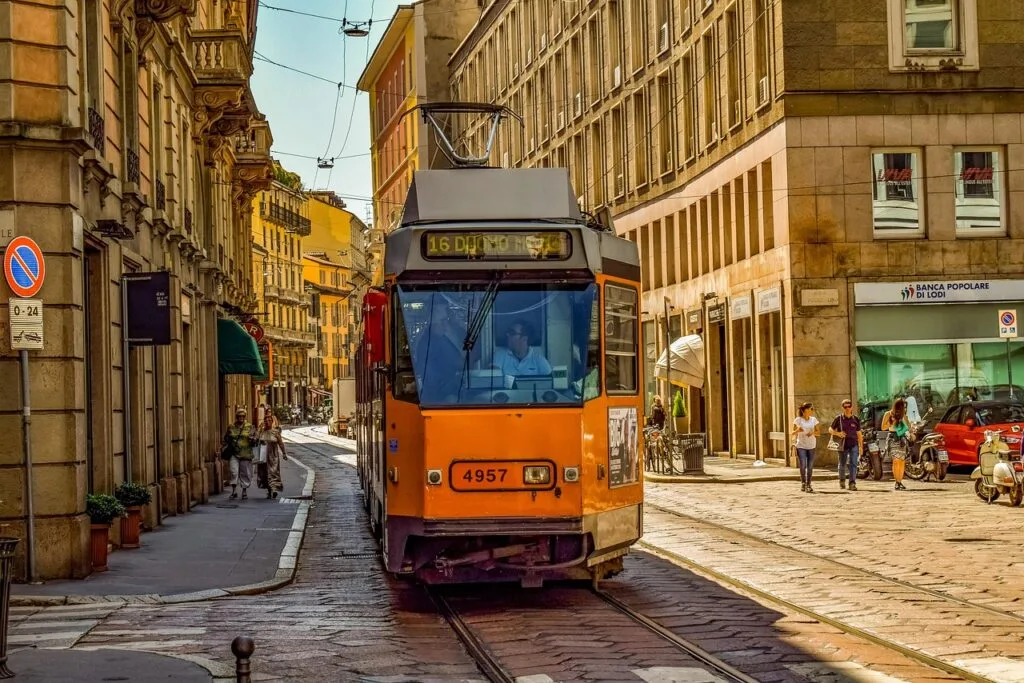 Tram orange circulant dans une rue pavée du centre de Milan