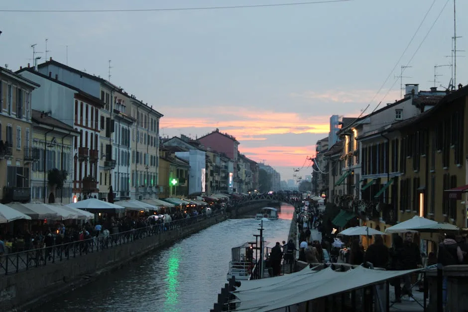 Canal des Navigli à Milan au crépuscule, terrasses et passants.