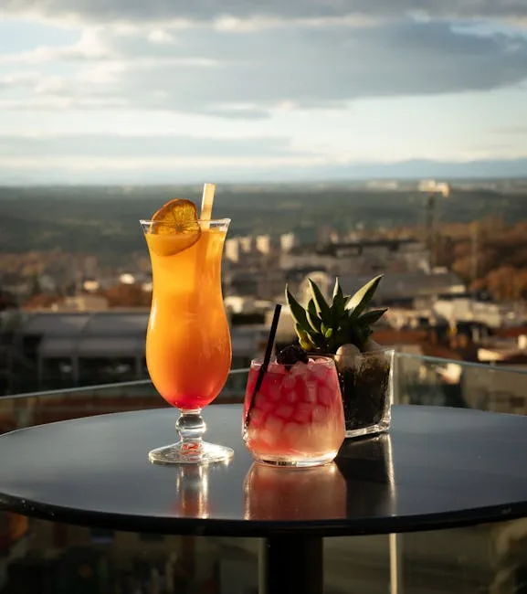 Deux cocktails colorés sur une table de terrasse, vue sur Milan.
