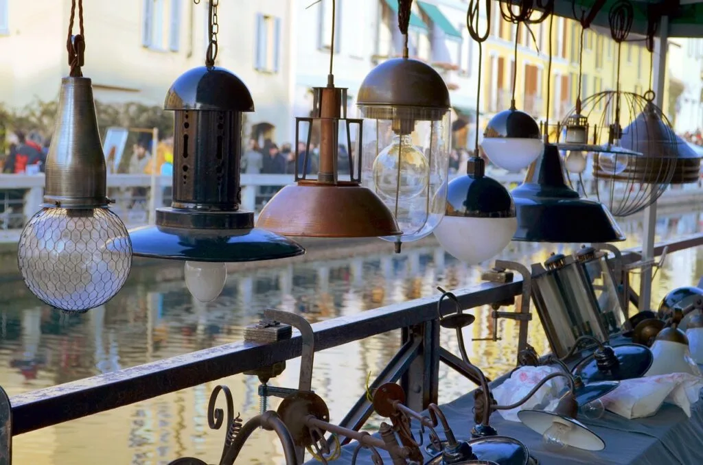 Luminaires vintage suspendus sur un étal du marché des Navigli
