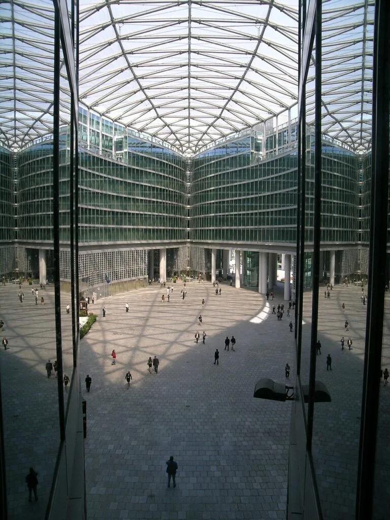 Grande cour pavée ombragée sous verrière dans un complexe de Milan