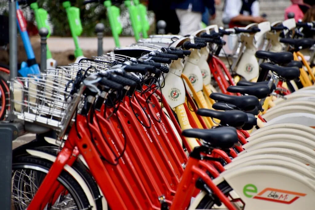 Vélos en libre-service rouges alignés sur une station à Milan