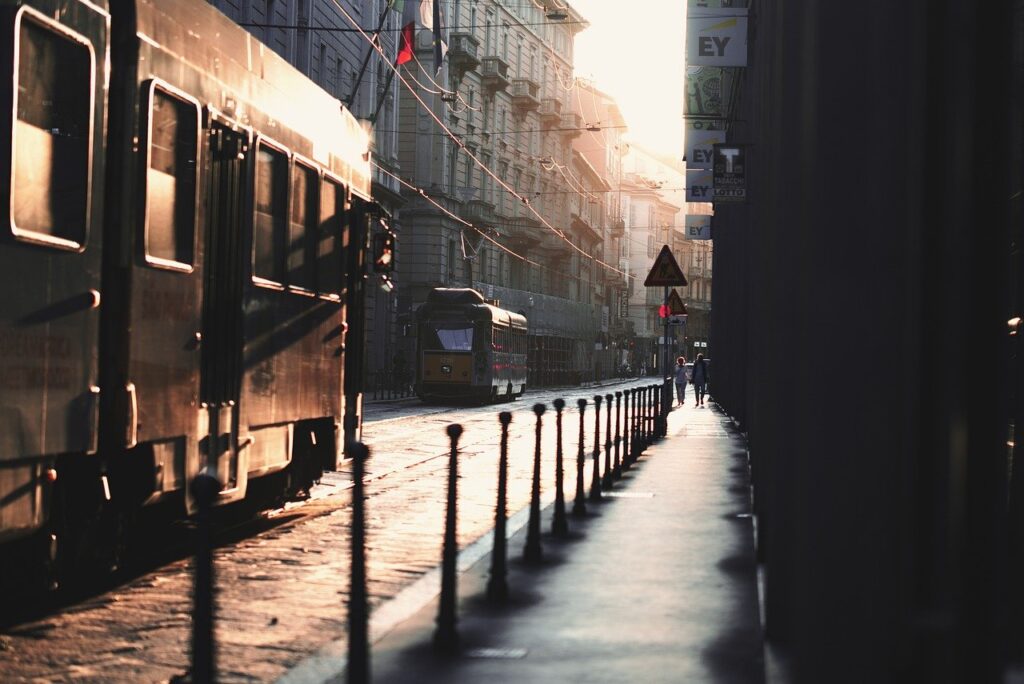 Tram fährt durch sonnenbeschienene Straße in Mailand
